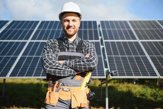 Glücklicher Solar Monteur in einem Solarpark